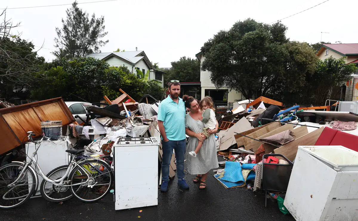 Lismore residents Tim Fry and Zara Coronakes and son Ezekiel outside their home on March 11 2022. Jason O'Brien/AAP, CC BY