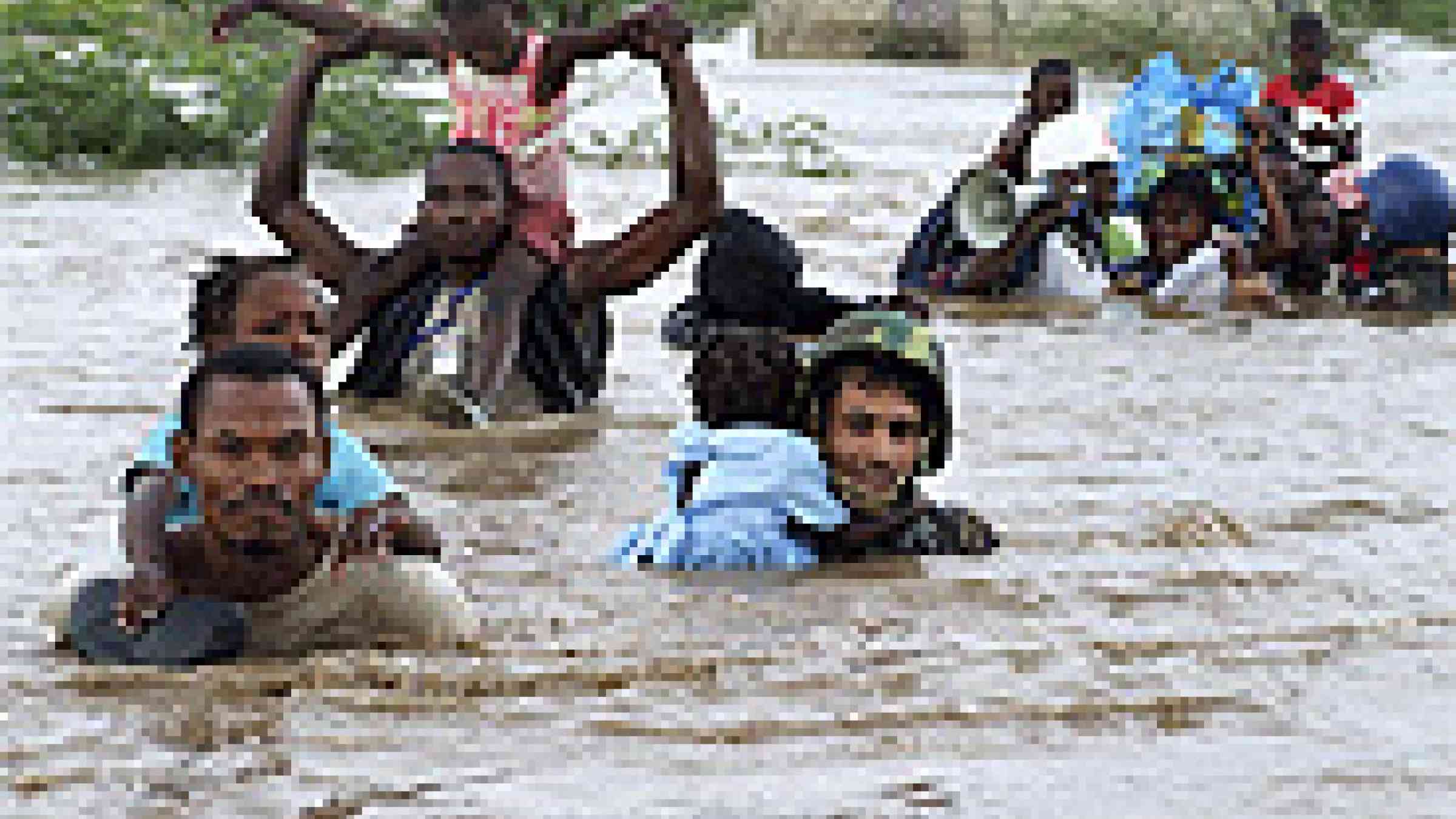 Members of the Jordanian battalion of the United Nations Stabilization Mission in Haiti (MINUSTAH) carry children through flood waters after a rescue from an orphanage destroyed by hurricane "Ike" 2008. UN Photo/Marco Dormino.