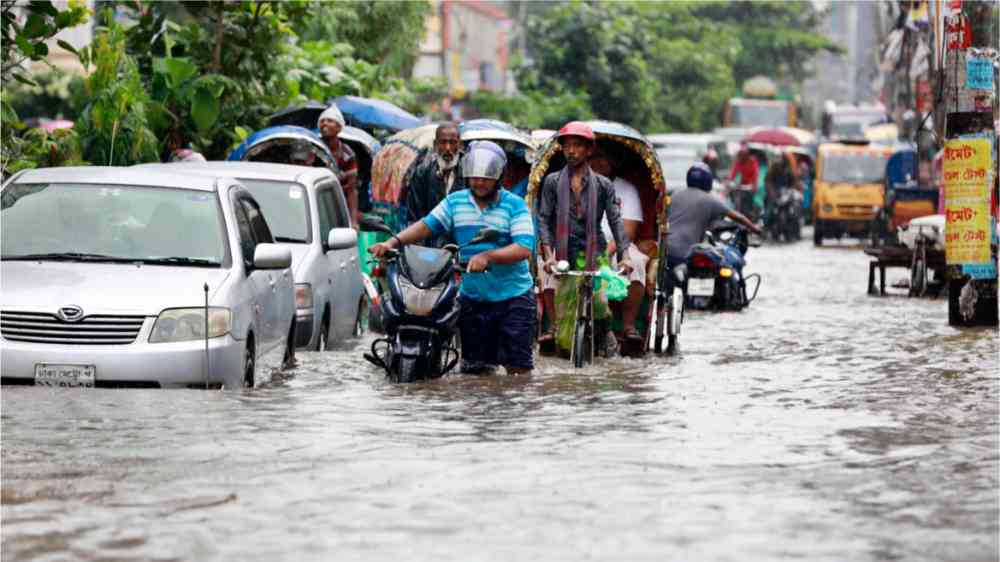 Dhaka residents wade in floodwater after heavy rains