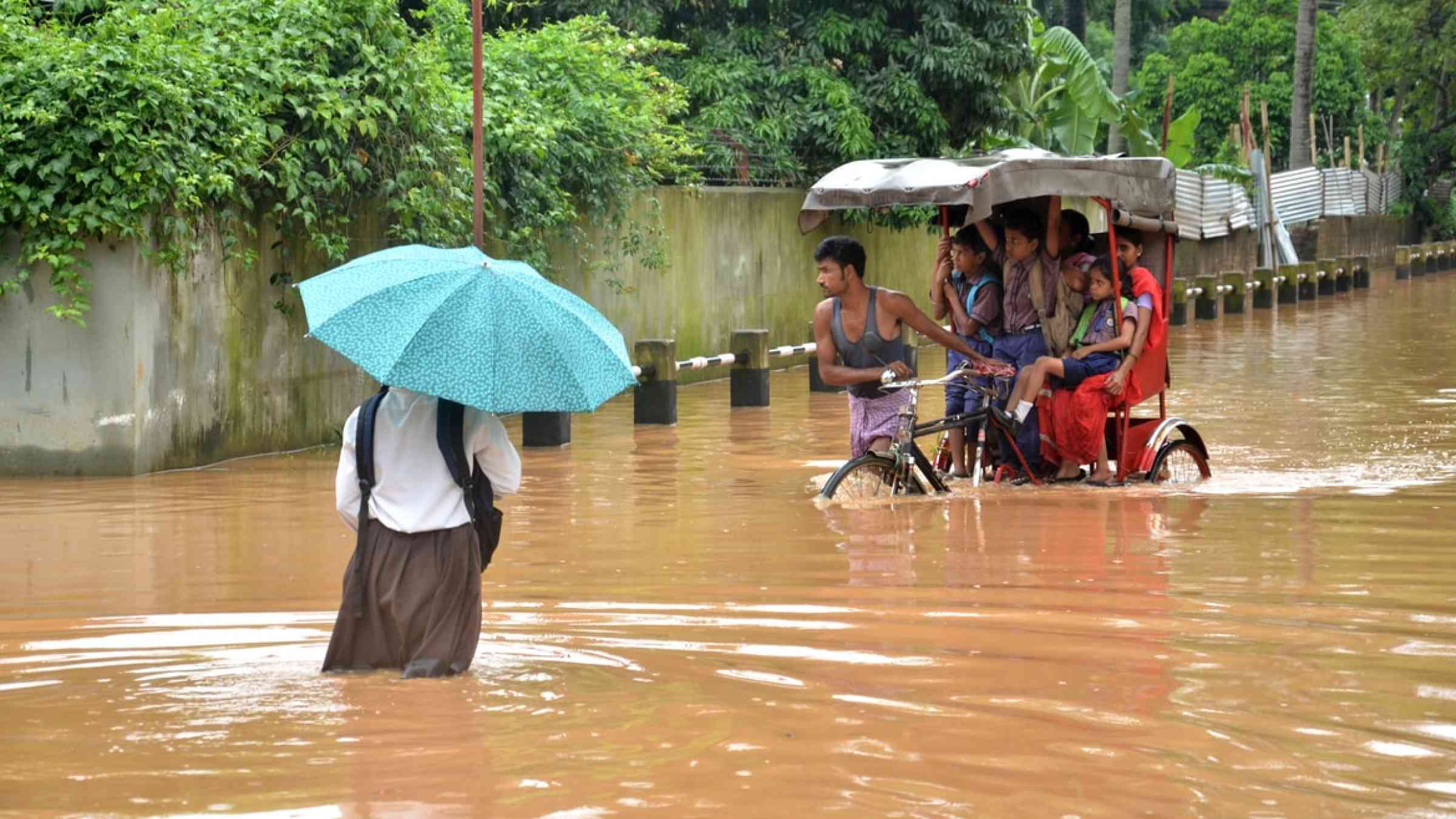 Commuters travel during floods in Guwahati, India.