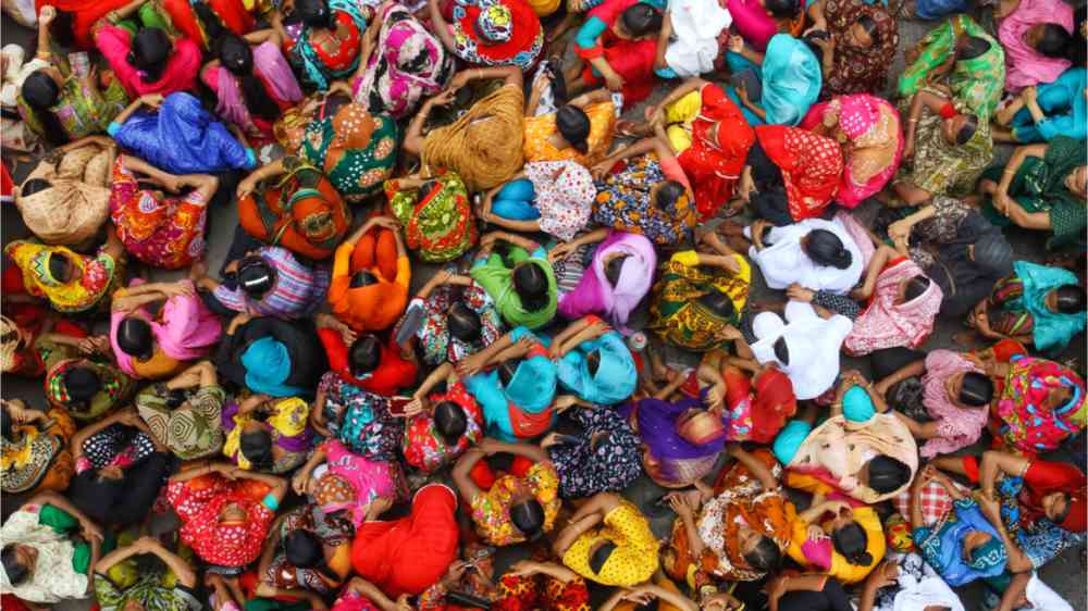 A group of Indian women sitting in colourful dresses on the floor in Bihar.