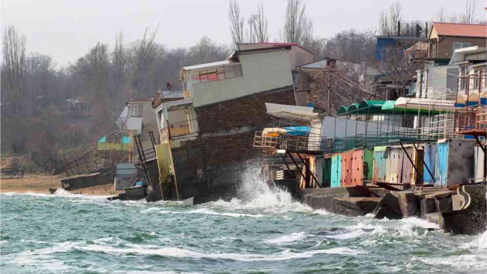 Houses being washed away through coastal erosion and sea level rise.