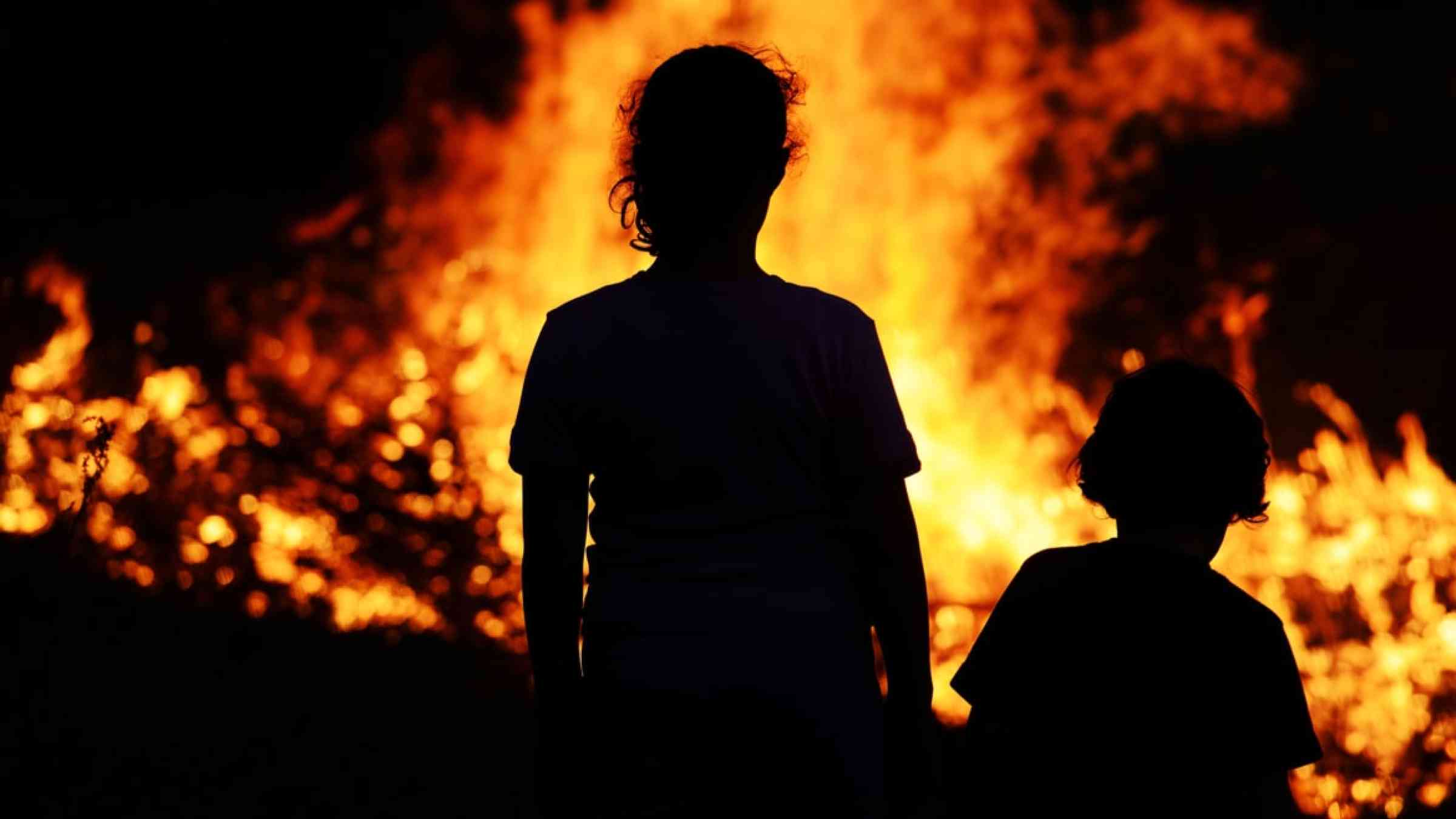 Children's shadow in front of a wildfire