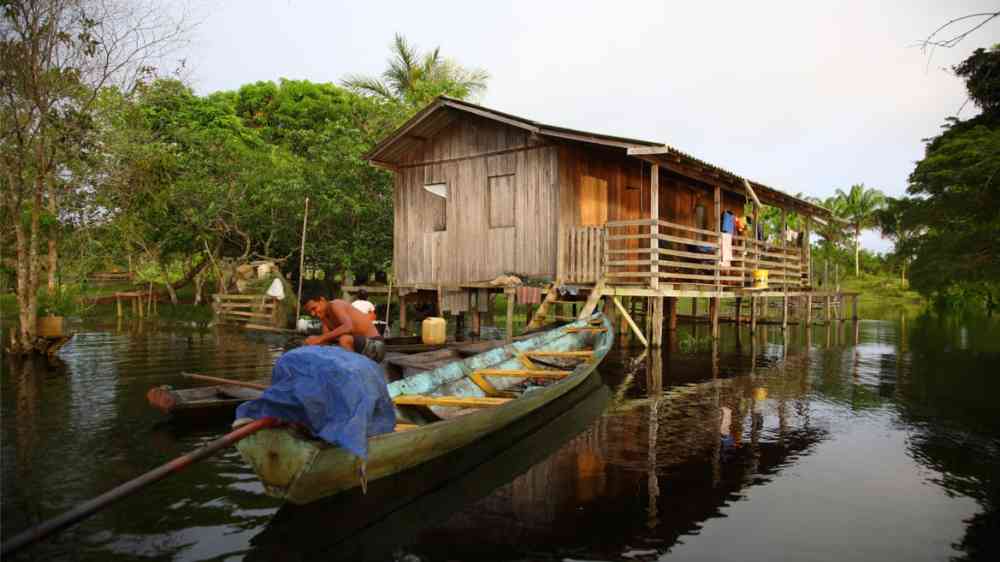 Amazon indigenous family living on floating wooden house in Brazil