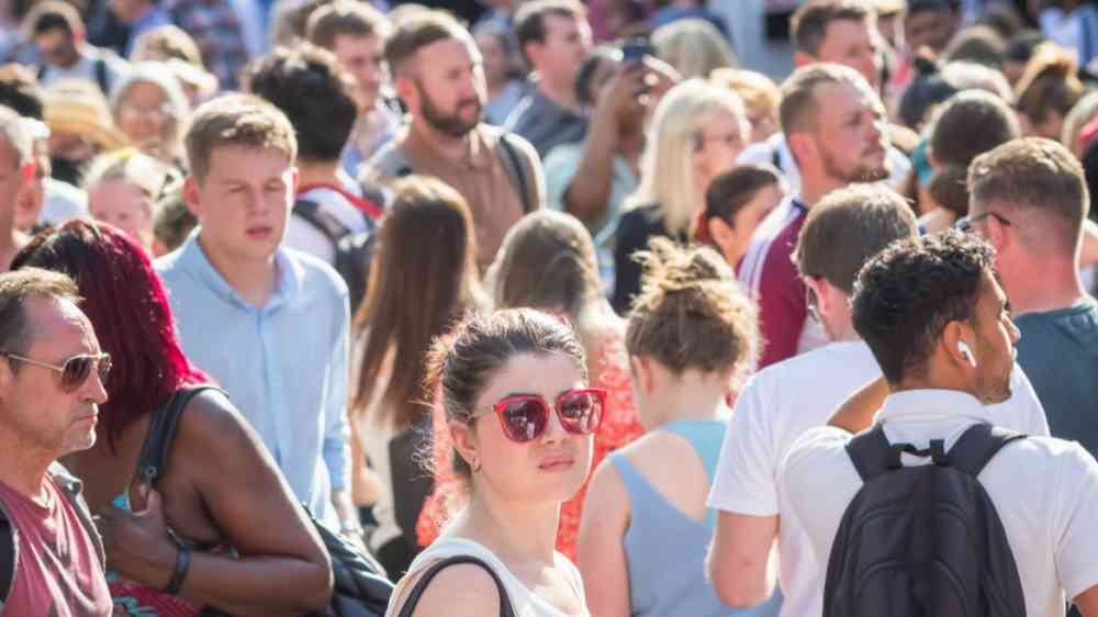 Crowd waiting for the train during a hot day in London, UK (2022)