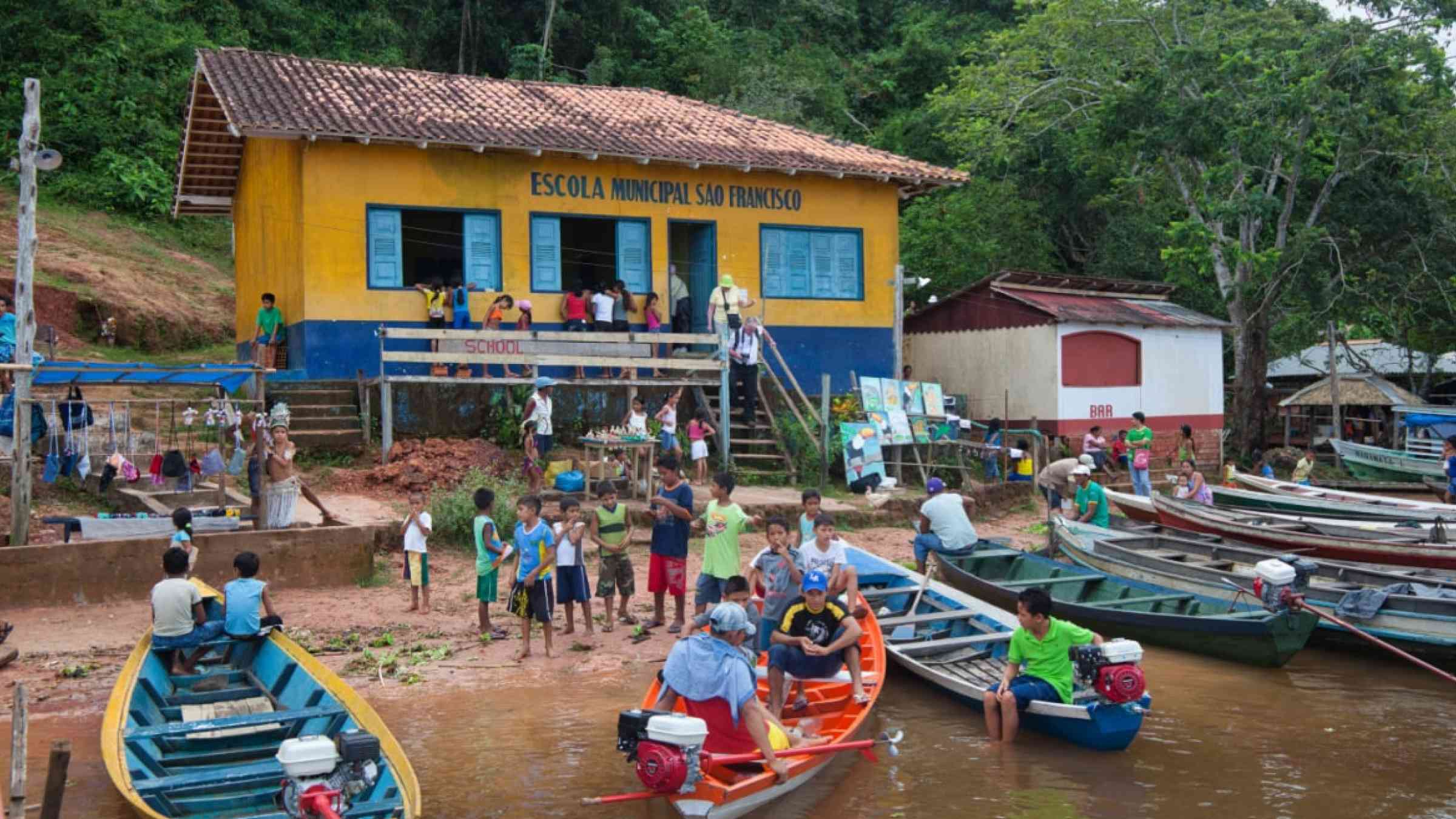 Lots of people and boats and the school at the village of Boca De Valeria on the Amazon River, Amazonas State, Brazil.
