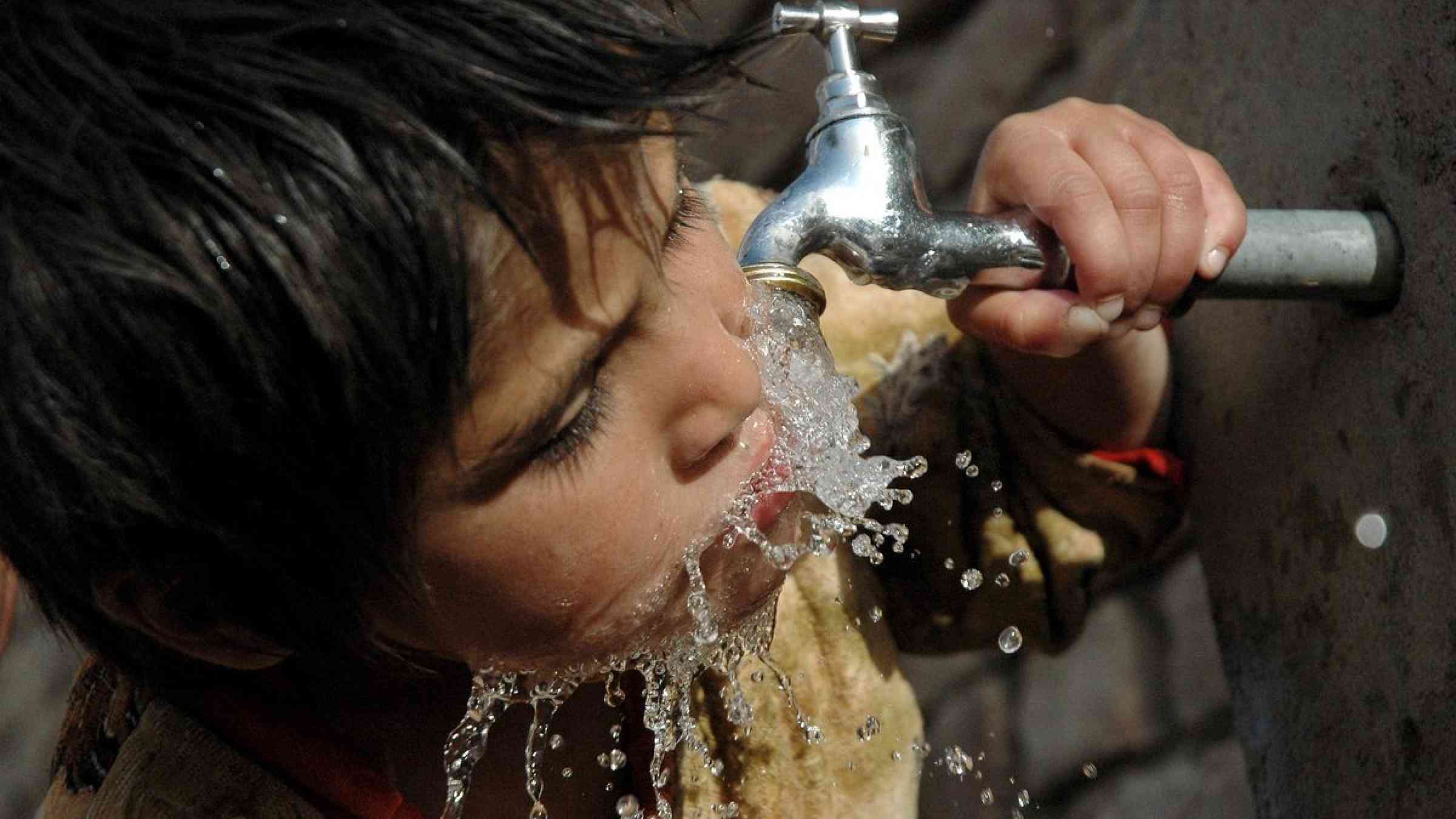 Child drinking from a tap, Nepal