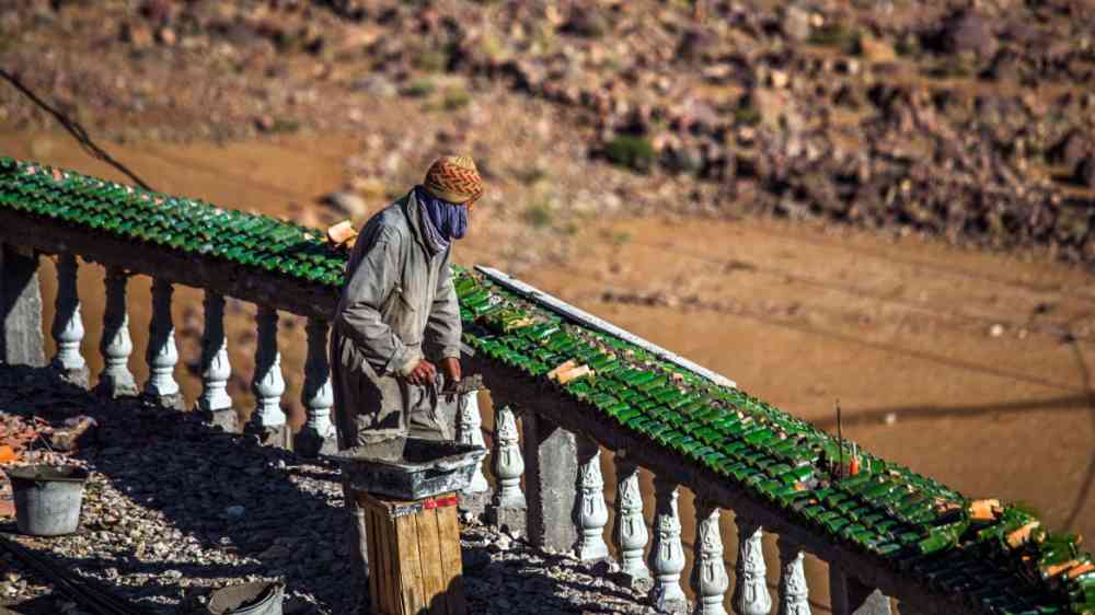 A Moroccan bricklayer prepares a surface for bricklaying in Tizi N'Tichka, Morocco