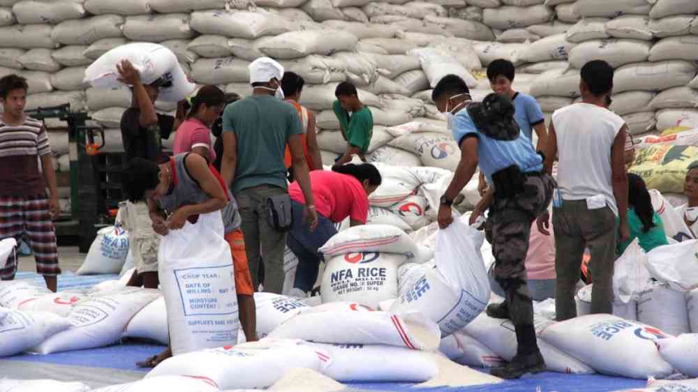 Relief workers distribute rice in a warehouse in the aftermath of Typhoon Haiyan