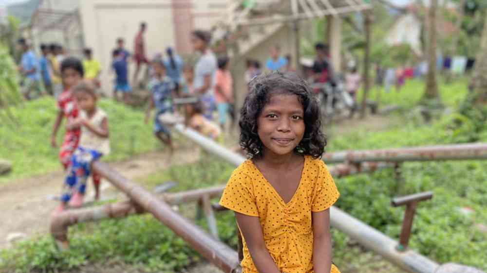 A child sits for a photo in the aftermath of Typhoon Rai in the Philippines