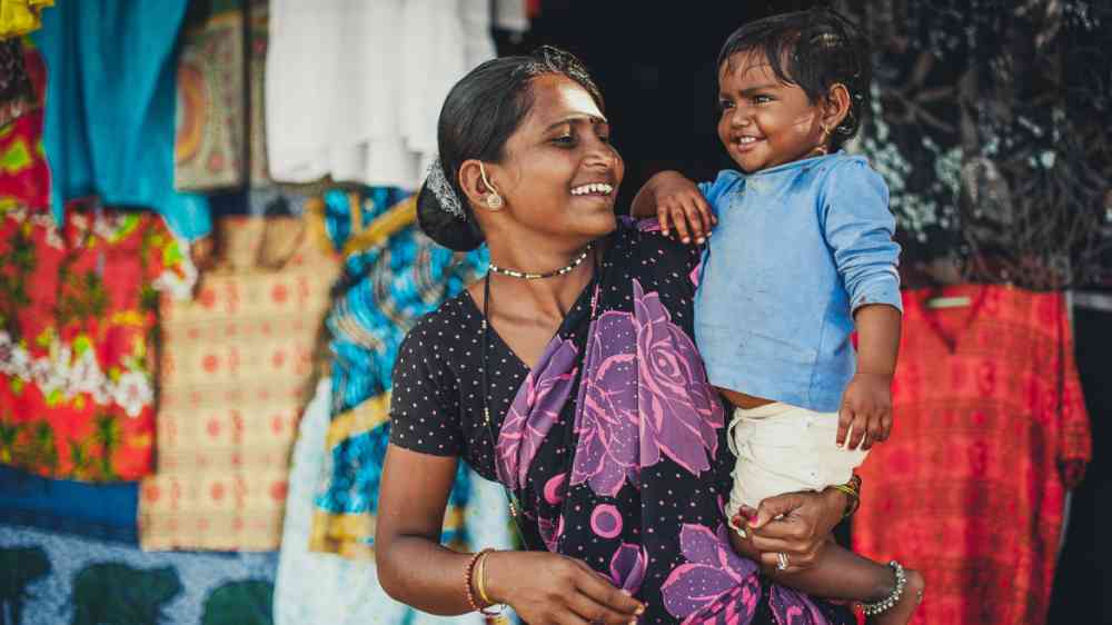 ndian woman and baby in her arms are smiling with very good mood in Goa, India