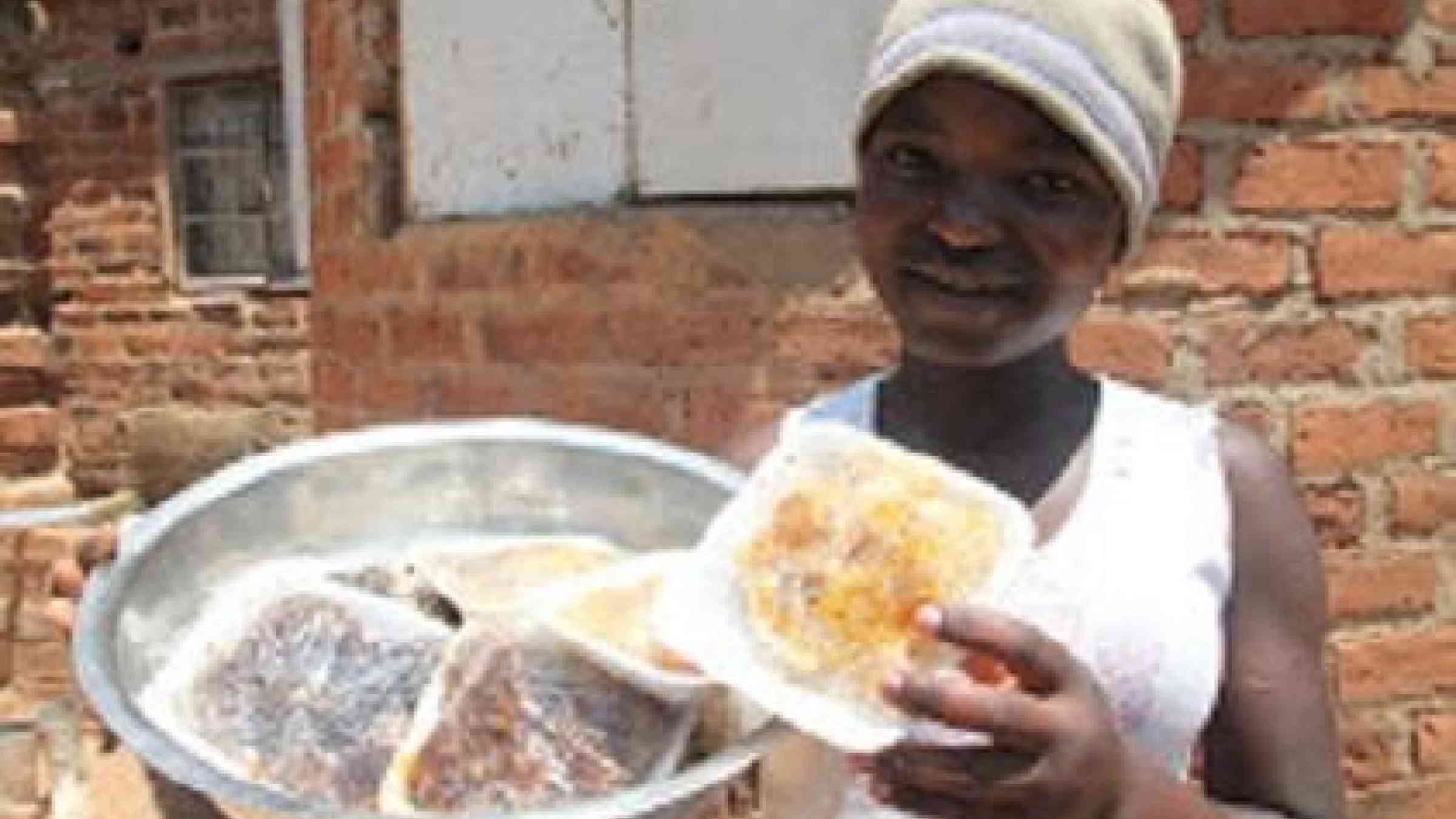 Beekeeper Ms. Precious Chaukura displays the honey she sells. Beekeeping is one method adopted by Zimbabwe's smallholders to offset the impact of drought on crops (Photo: UNISDR/Tawanda Majoni)