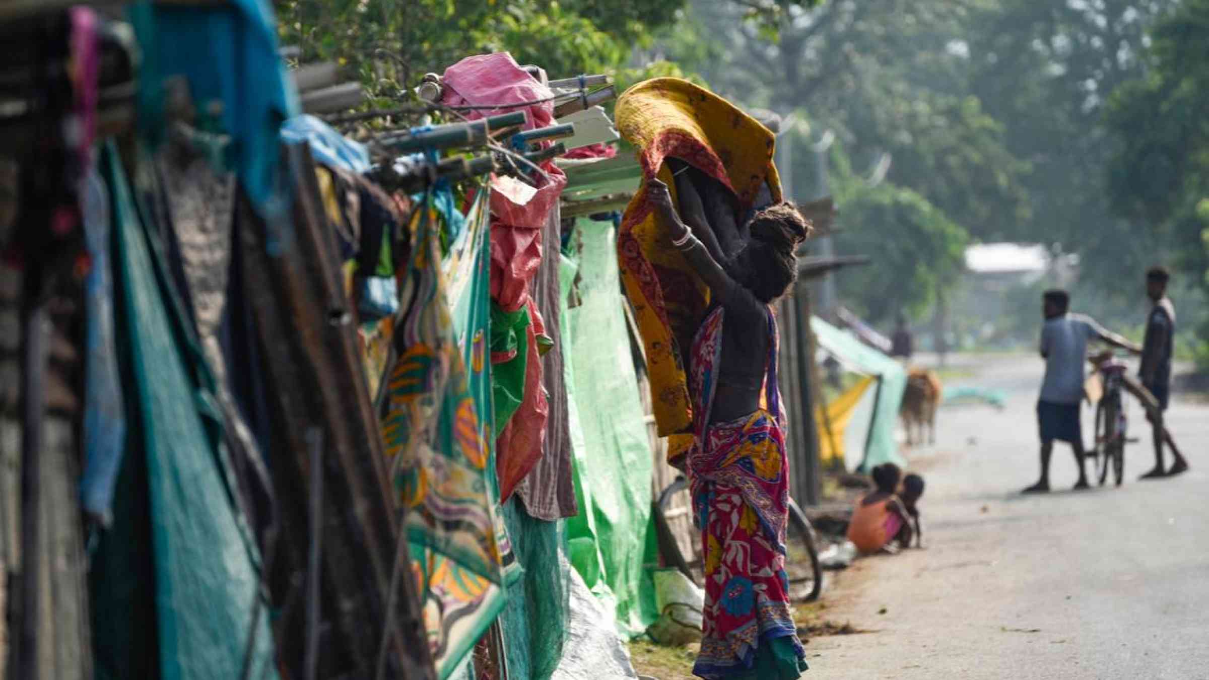 Villagers in a makeshift shelter on a high lane area after flooding in Assam, India (June 2020). Talukdar David/Shutterstock