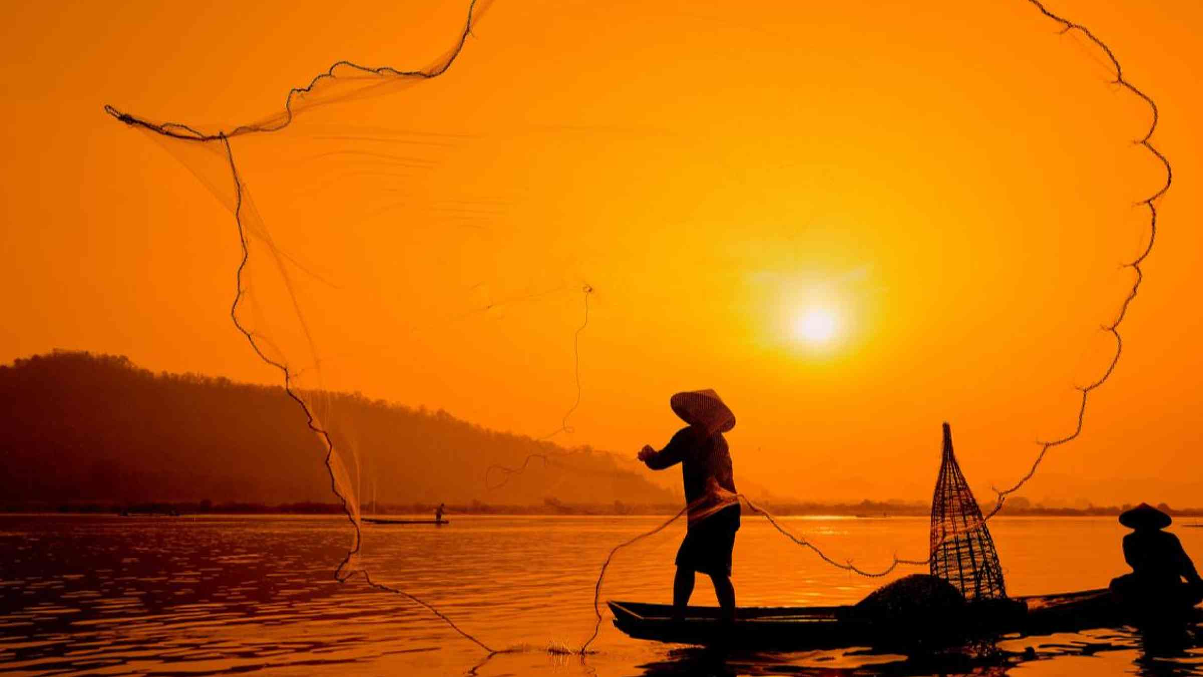 Two fishermen on the Mekong River. Sunti/Shutterstock