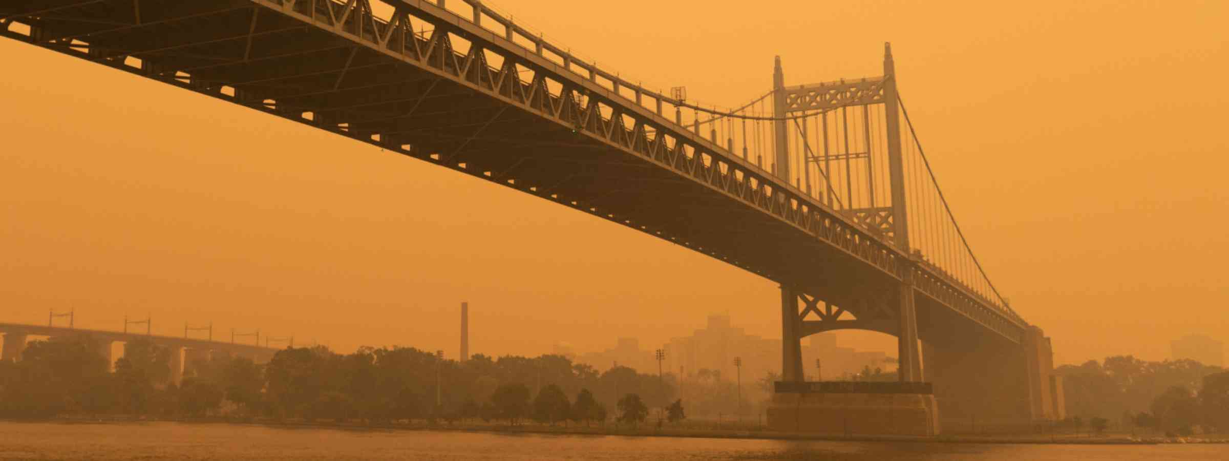 Triborough bridge along the East River in New York City with massive air pollution from wildfire