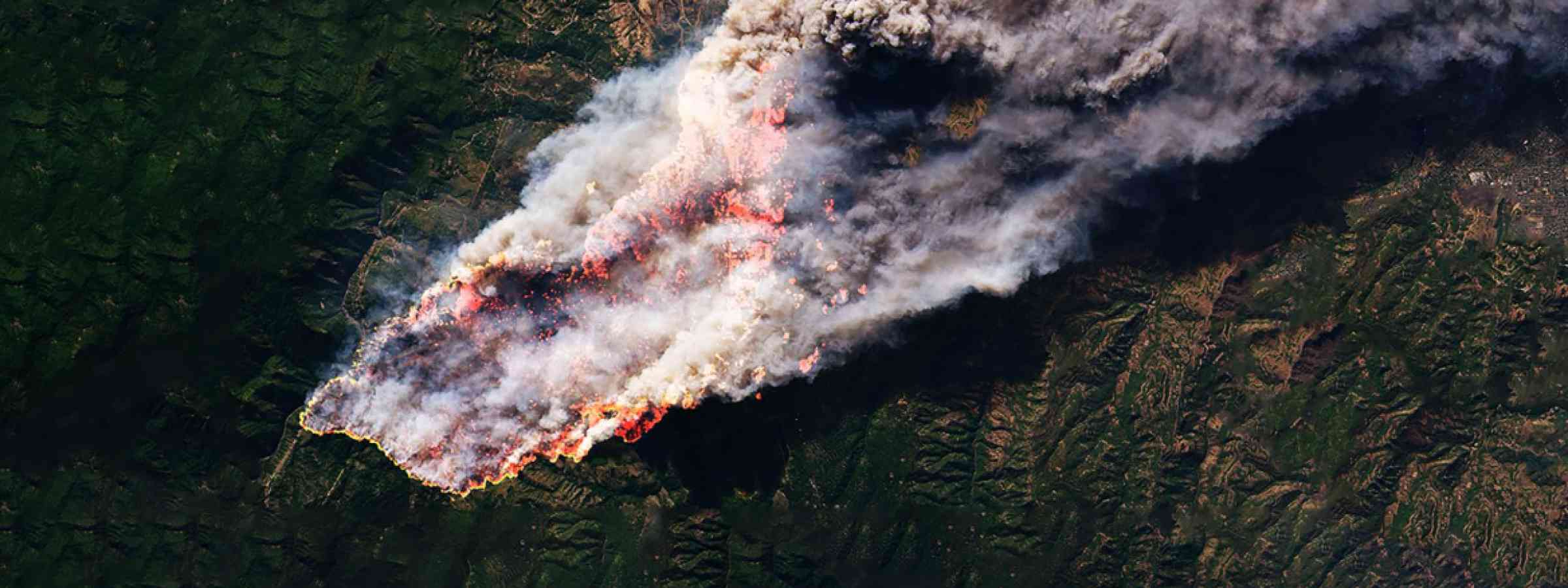 Wildfire burning land, photograph taken from above  